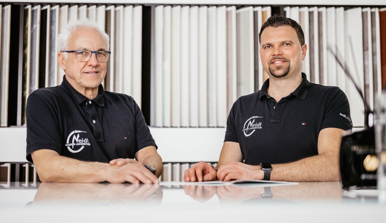 Team der Maler Neidl GmbH im Gespraech am Beratungstisch Senior und Junior Neidl