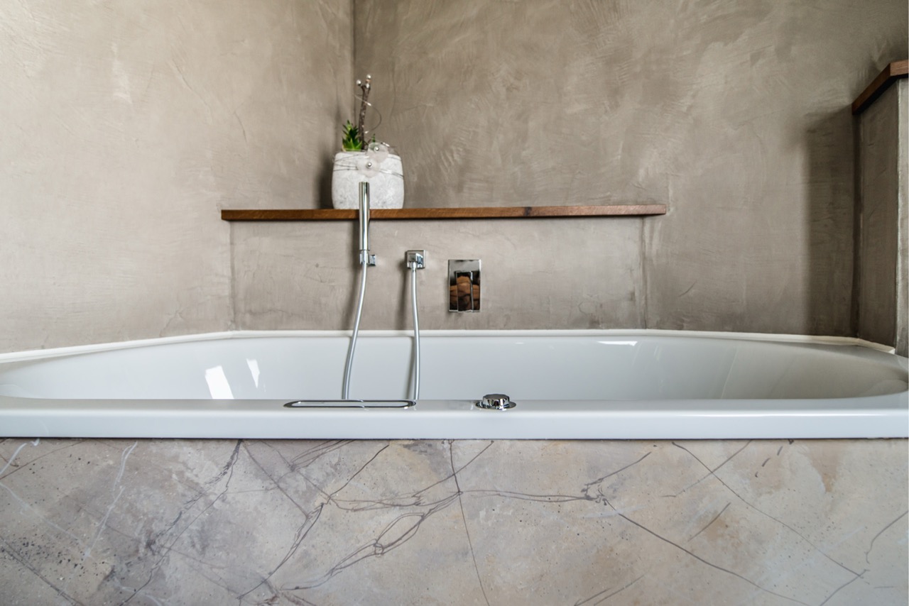 Badewanne mit mineralischer fugenloser Wandfläche