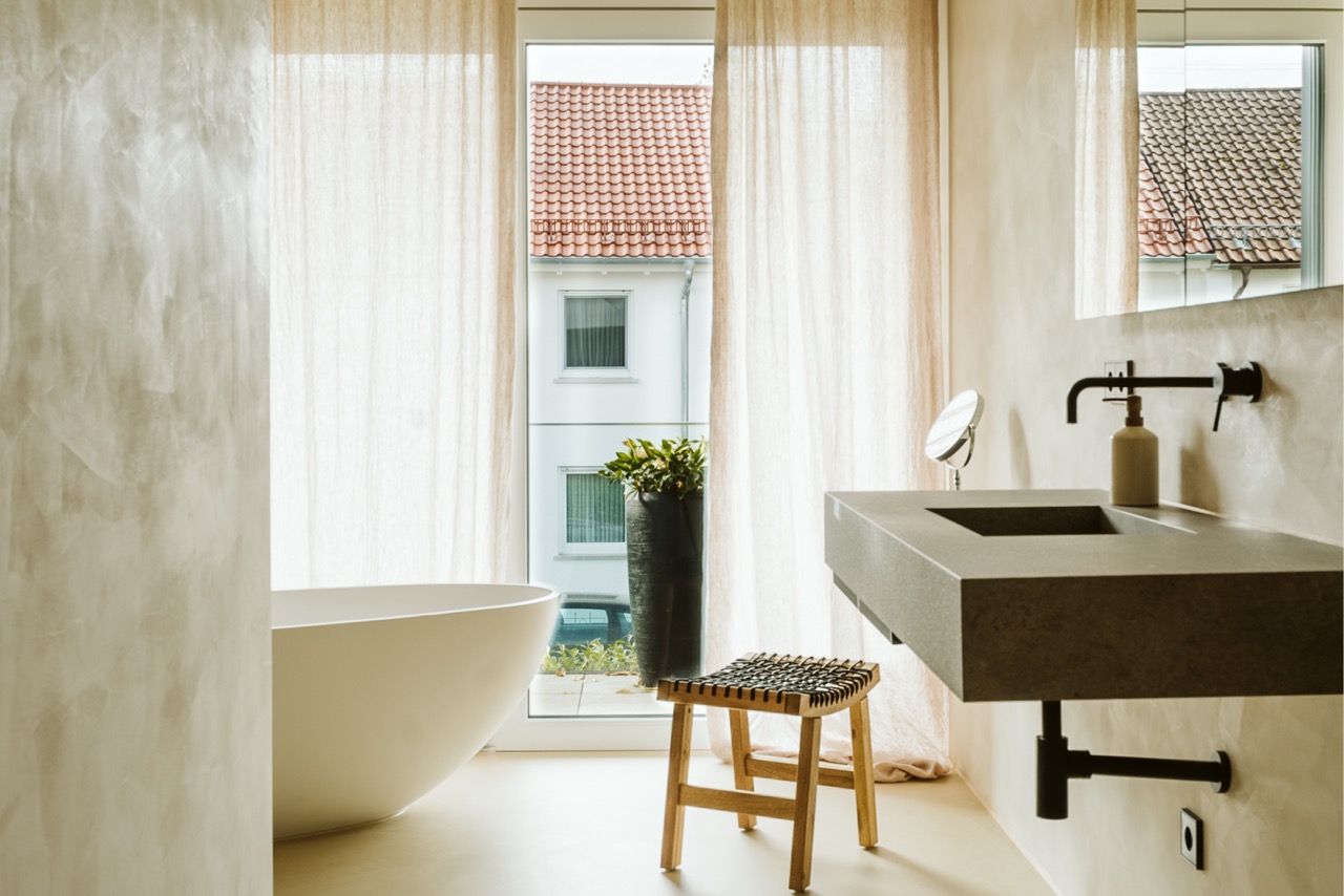 Helles fugenloses Bad mit freistehender Badewanne am Fenster