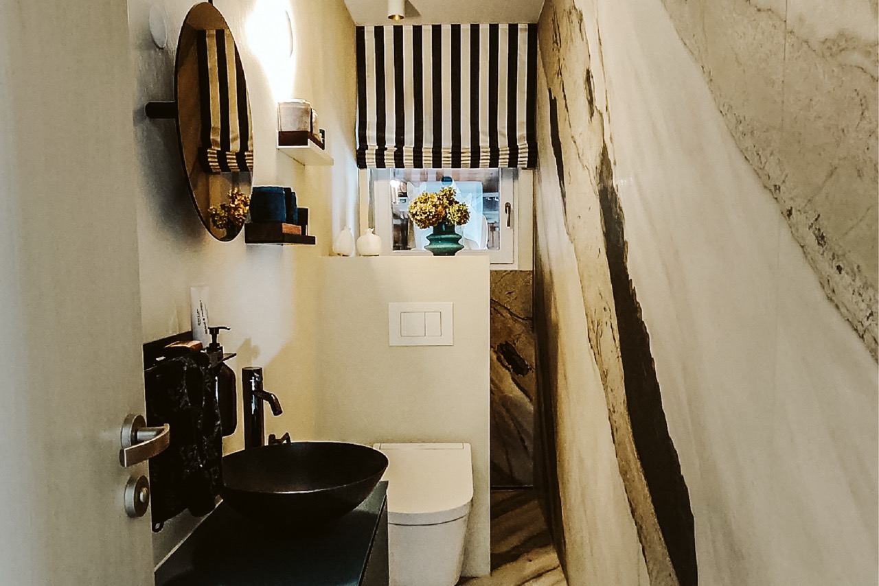 Kleines fugenloses Bad mit dunklem Waschtisch und WC
