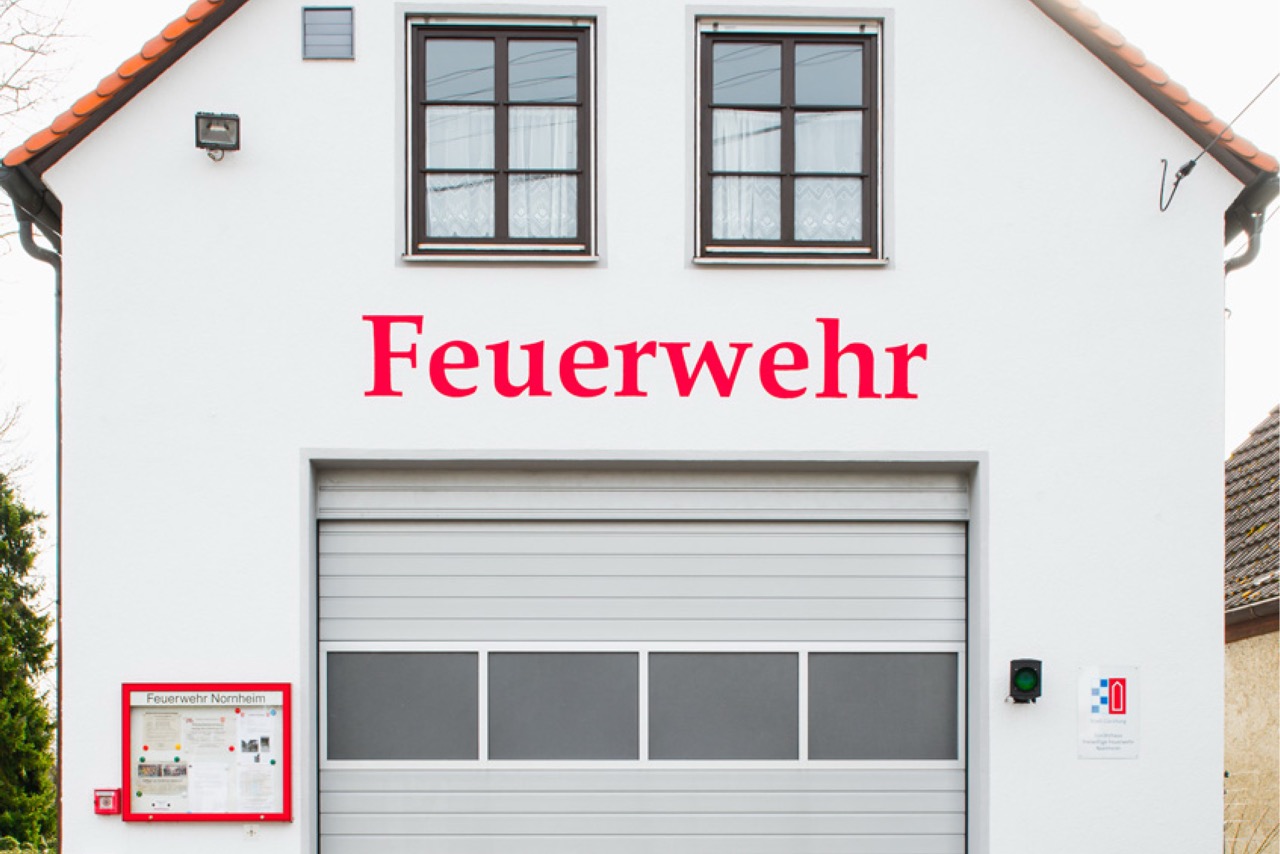 Feuerwehrhaus mit heller Fassade und roter Beschriftung