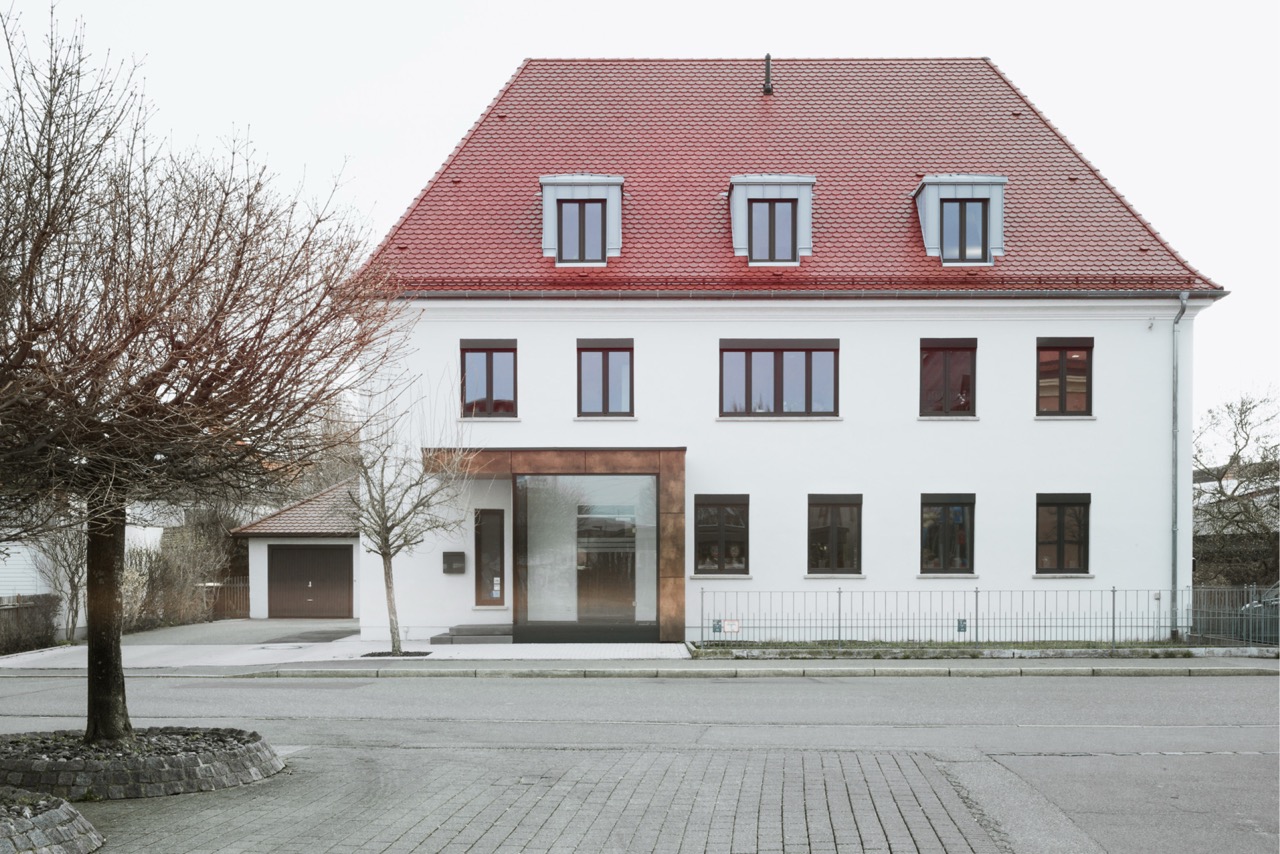 Wohnhaus mit renovierter heller Fassade und rotem Dach