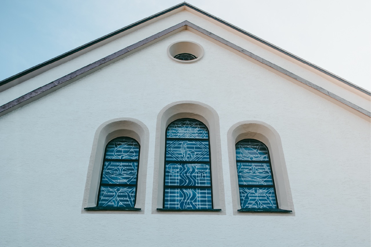 Kirchenfenster mit hell gestalteter Fassade