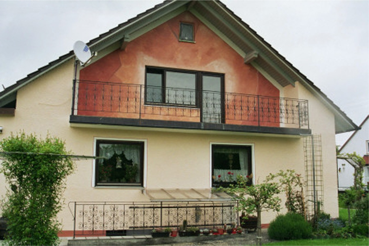 Wohnhaus mit zweifarbiger Fassadengestaltung und Balkon