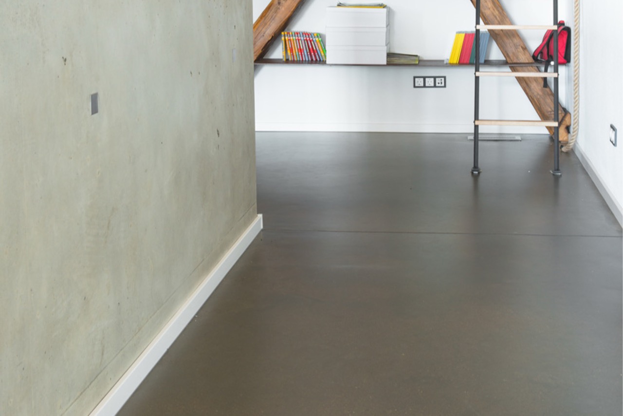Flur mit grauem Loftboden und mineralischer Wandgestaltung