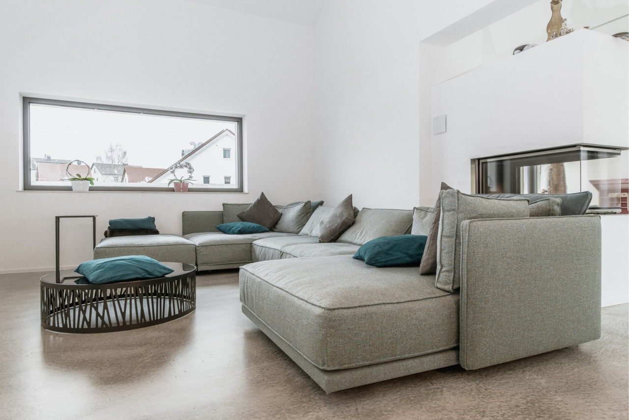 Wohnzimmer mit hellem Loftboden und Sofa