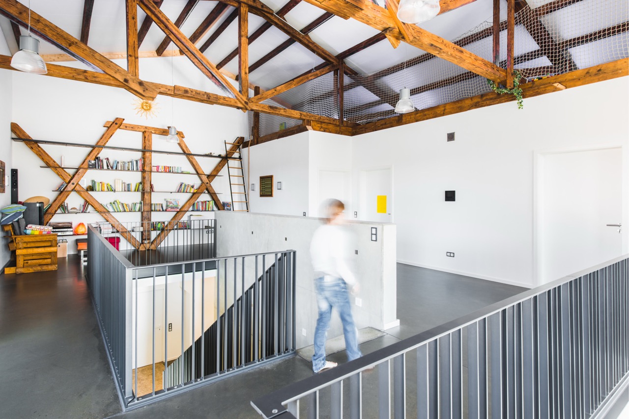 Offener Loftbereich mit Holzbalken und fugenlosem Boden