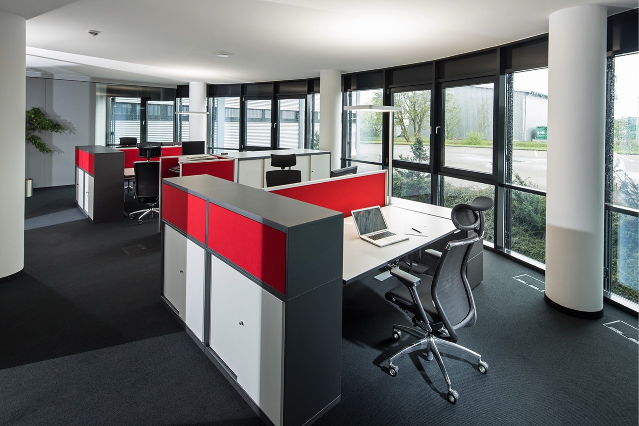 Bürofläche mit roter Akzentgestaltung und Arbeitsplätzen