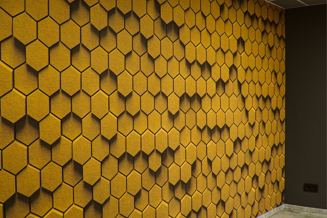 Akustik-Designwand mit goldener Wabenstruktur
