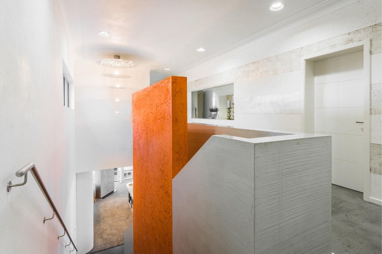 Treppenhaus mit farbiger Akzentwand und hellem Raumdesign